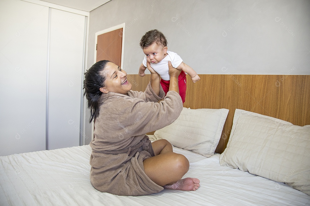 Mãe jovem cuidadando de seu filho sobre quarto