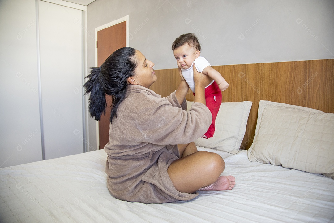 Mãe jovem cuidadando de seu filho sobre quarto