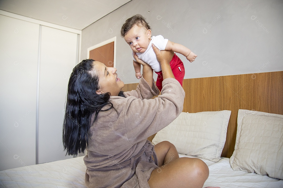 Mãe jovem cuidadando de seu filho sobre quarto