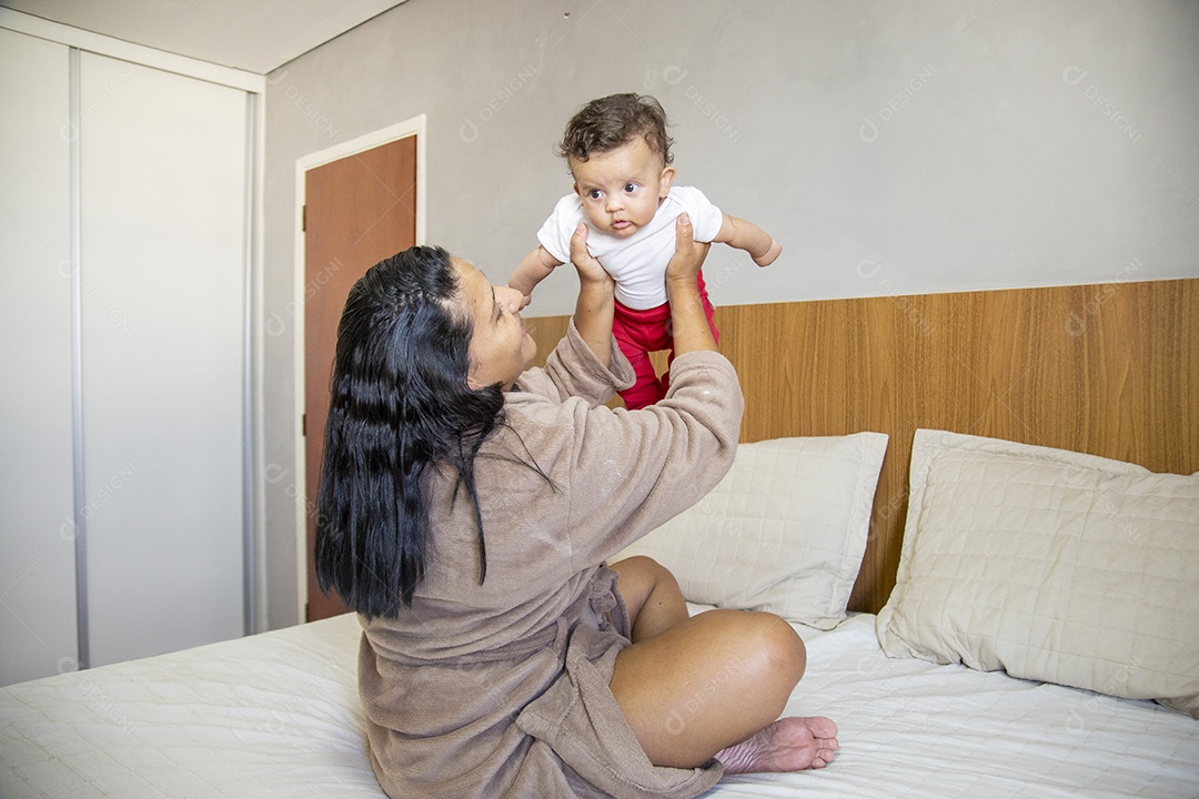 Mãe jovem cuidadando de seu filho sobre quarto