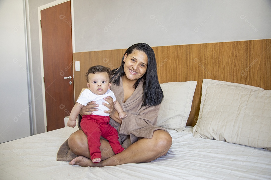 Mãe jovem cuidadando de seu filho sobre quarto