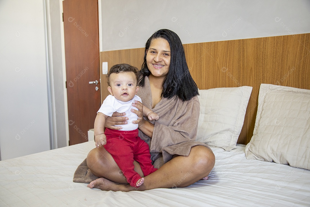 Mãe jovem cuidadando de seu filho sobre quarto