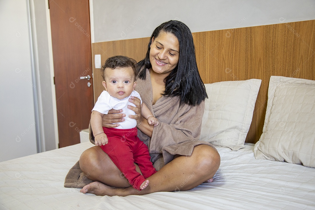 Mãe jovem cuidadando de seu filho sobre quarto