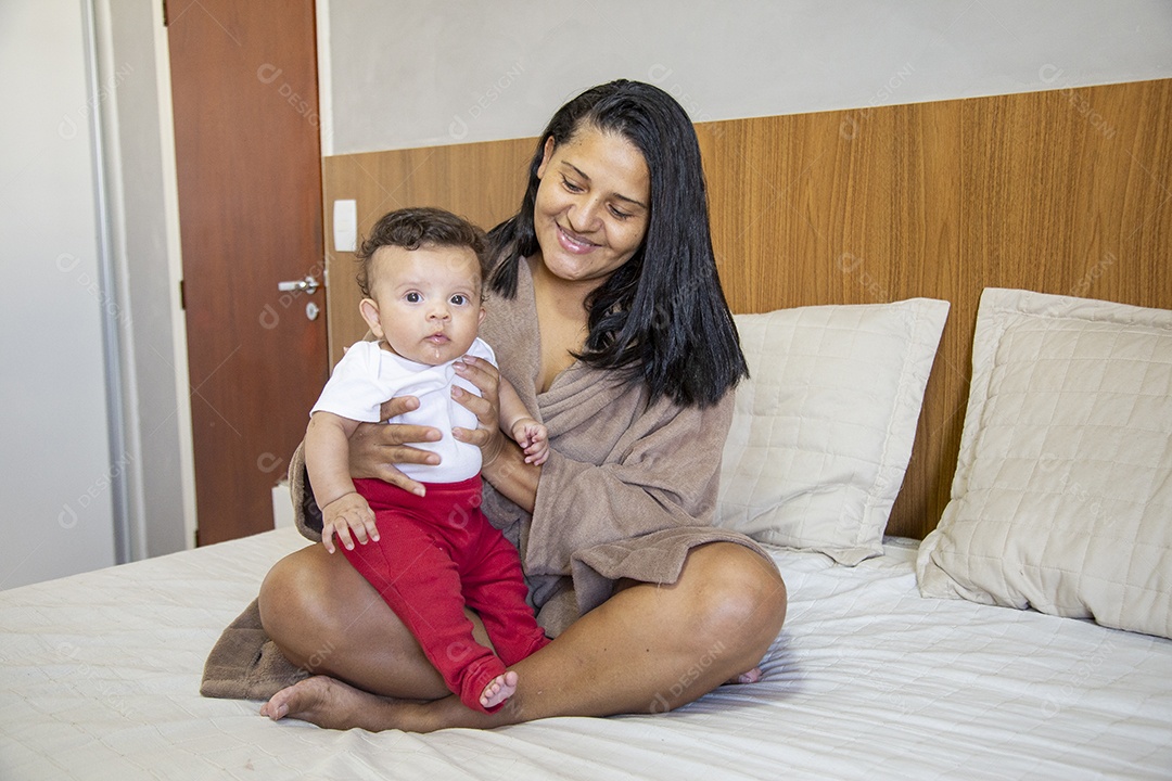 Mãe jovem cuidadando de seu filho sobre quarto