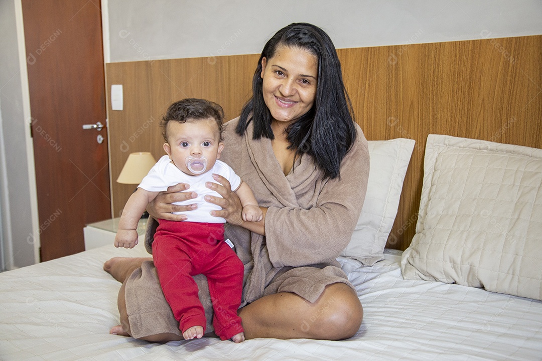 Mãe jovem cuidadando de seu filho sobre quarto