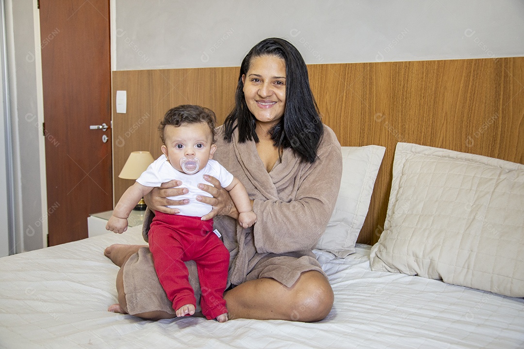 Mãe jovem cuidadando de seu filho sobre quarto