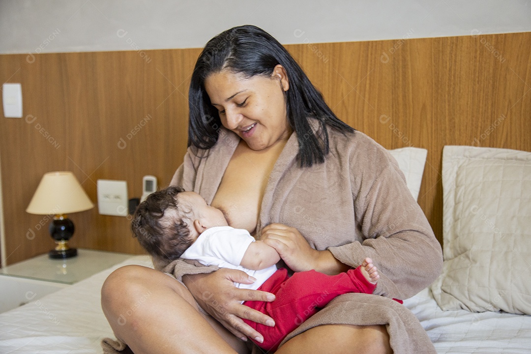 Mãe jovem cuidadando de seu filho sobre quarto