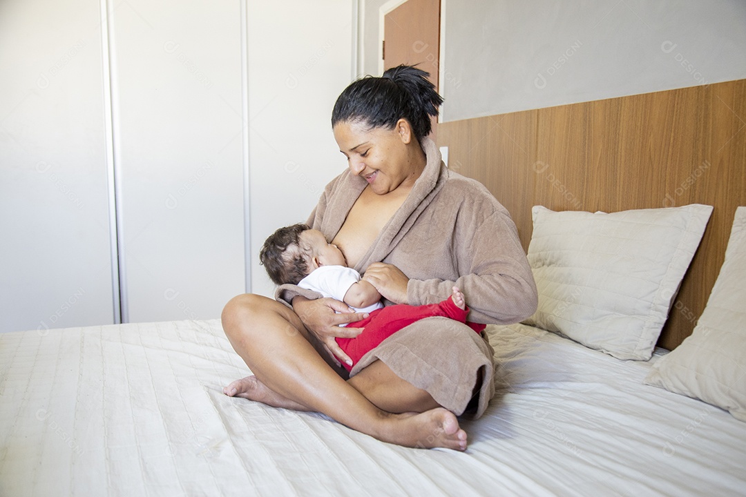 Mãe jovem cuidadando de seu filho sobre quarto