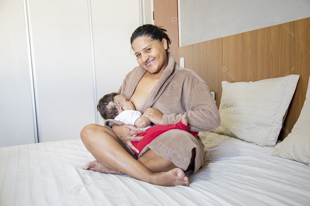 Mãe jovem cuidadando de seu filho sobre quarto