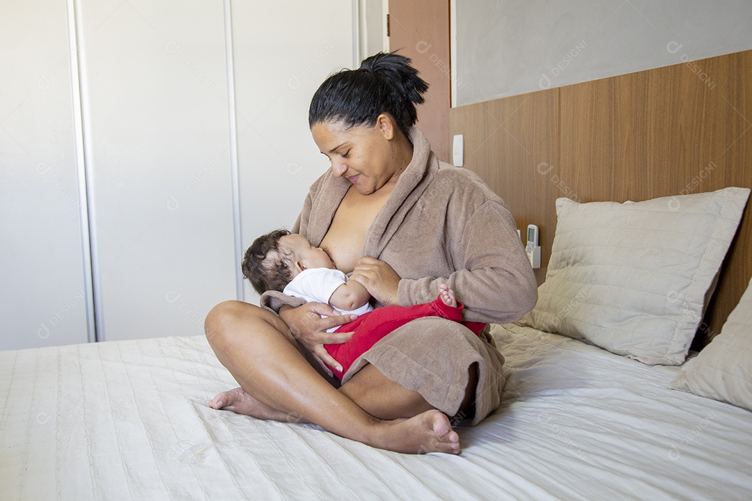 Mãe jovem cuidadando de seu filho sobre quarto