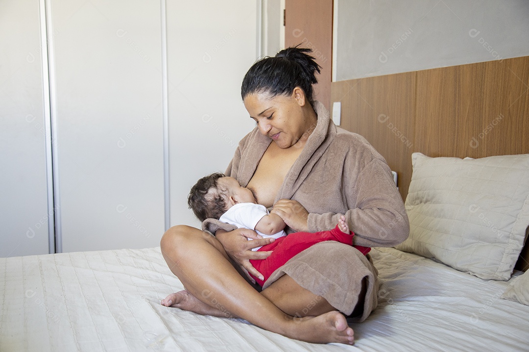 Mãe jovem cuidadando de seu filho sobre quarto