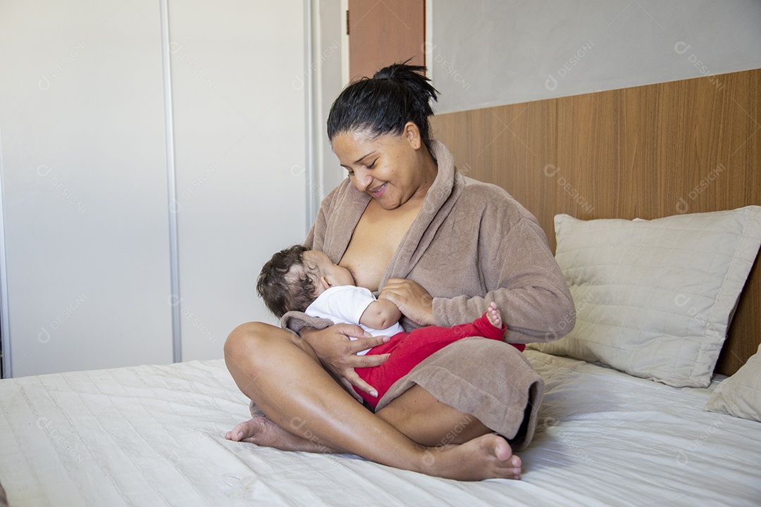 Mãe jovem cuidadando de seu filho sobre quarto