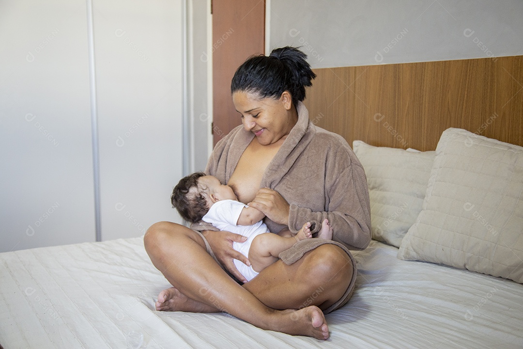 Mãe jovem cuidadando de seu filho sobre quarto