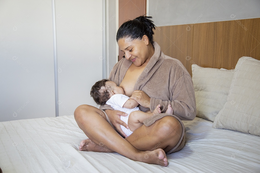 Mãe jovem cuidadando de seu filho sobre quarto