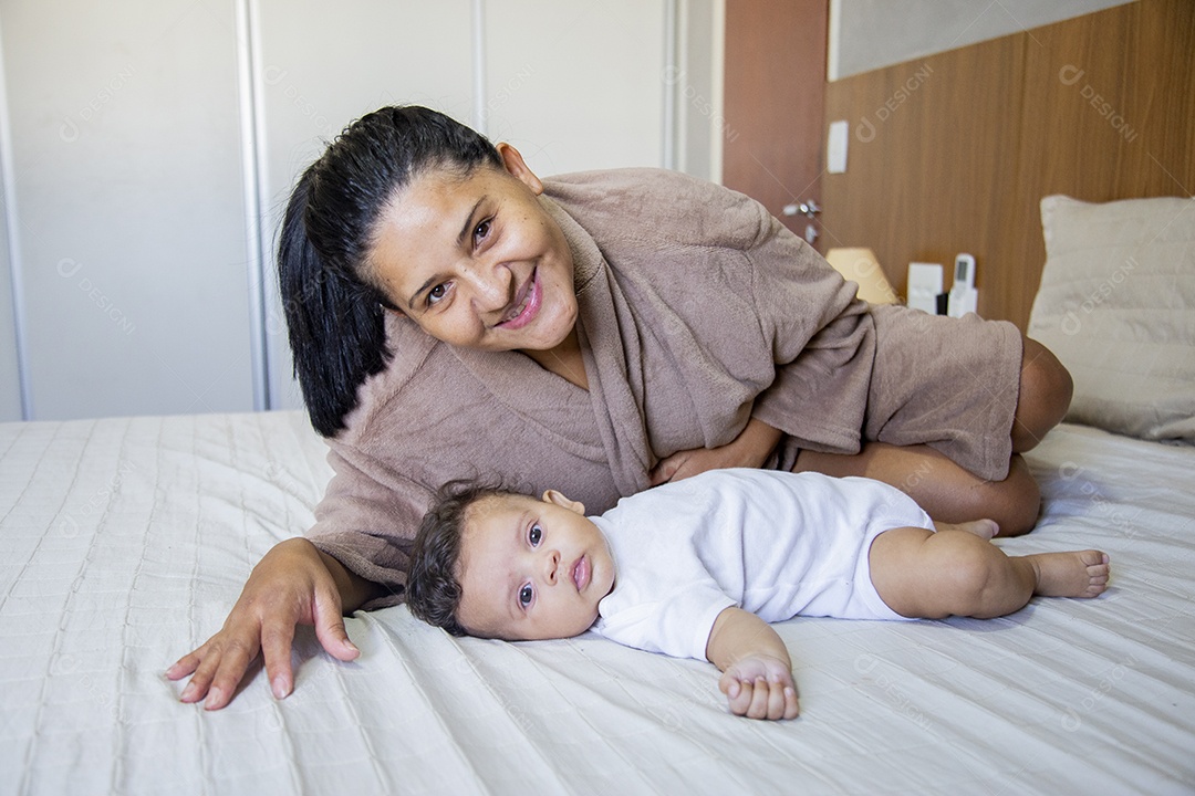Mãe jovem cuidadando de seu filho sobre quarto