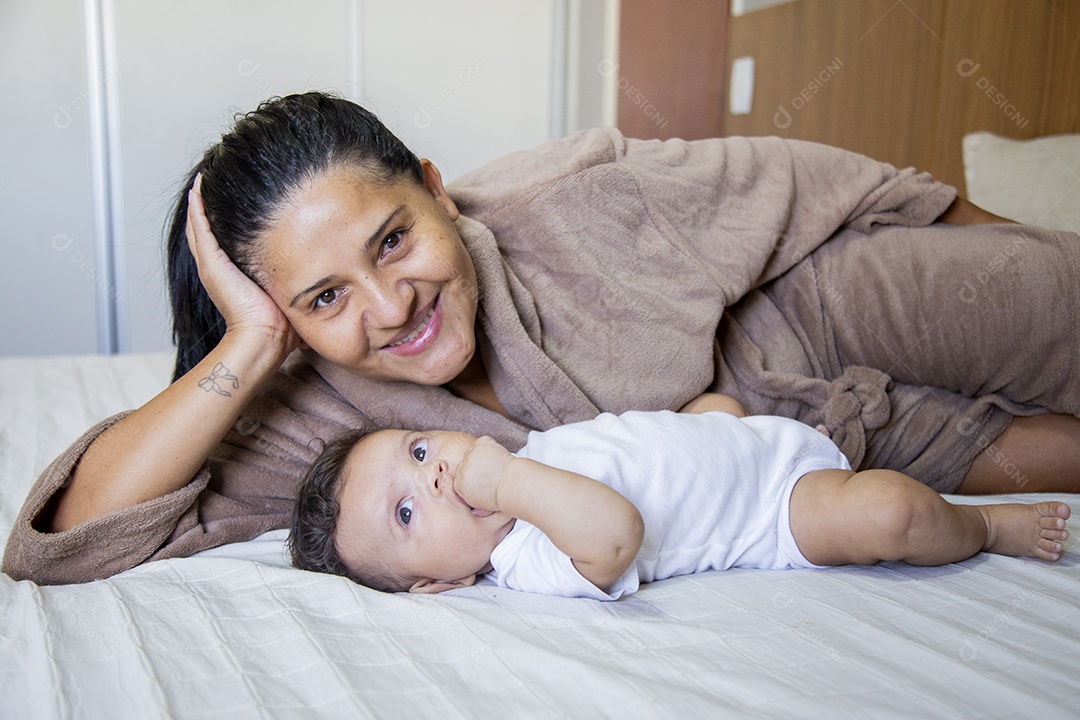 Mãe jovem cuidadando de seu filho sobre quarto