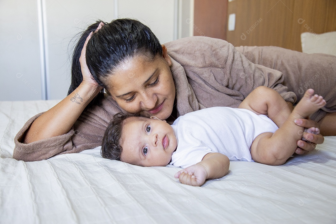 Mãe jovem cuidadando de seu filho sobre quarto