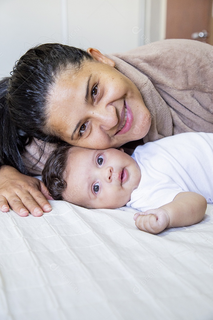 Mãe jovem cuidadando de seu filho sobre quarto