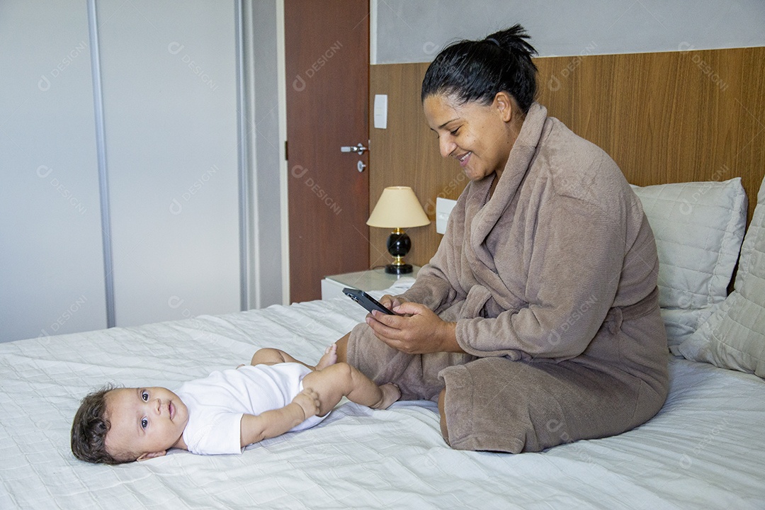 Mãe jovem cuidadando de seu filho sobre quarto