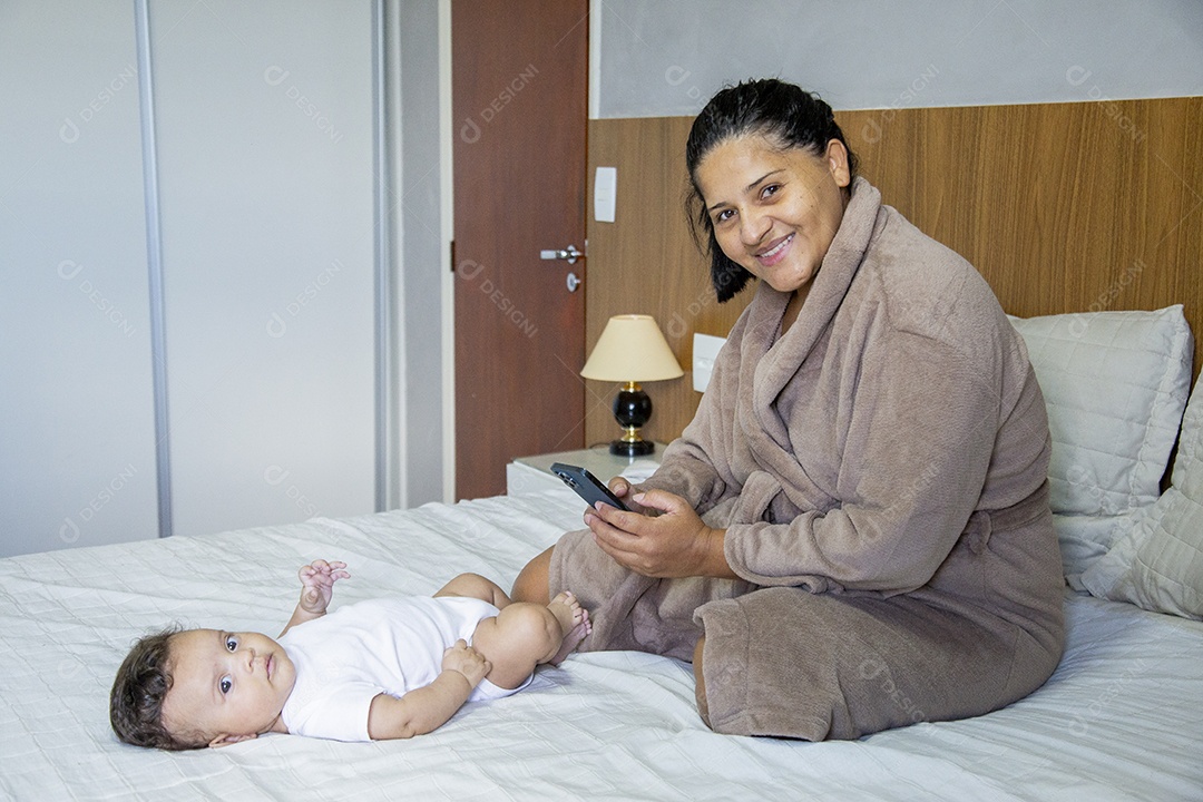 Mãe jovem cuidadando de seu filho sobre quarto