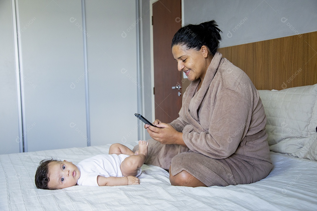 Mãe jovem cuidadando de seu filho sobre quarto