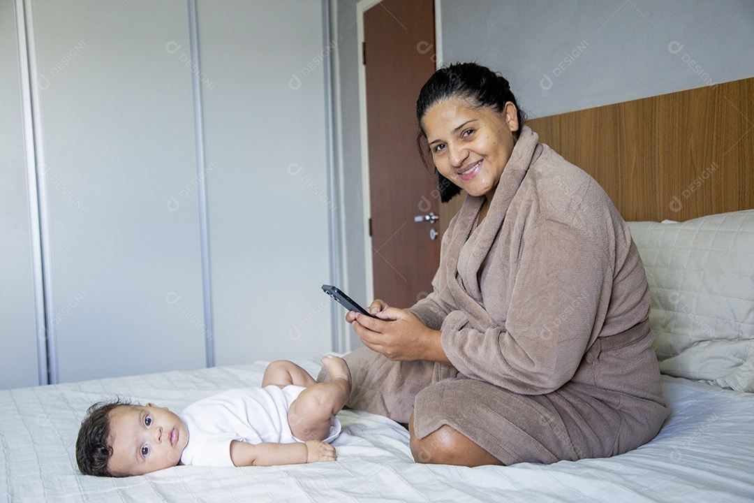 Mãe jovem cuidadando de seu filho sobre quarto