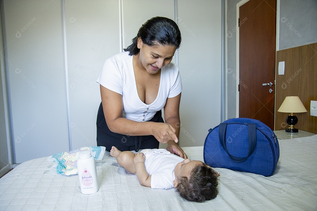 Mãe jovem cuidadando de seu filho sobre quarto