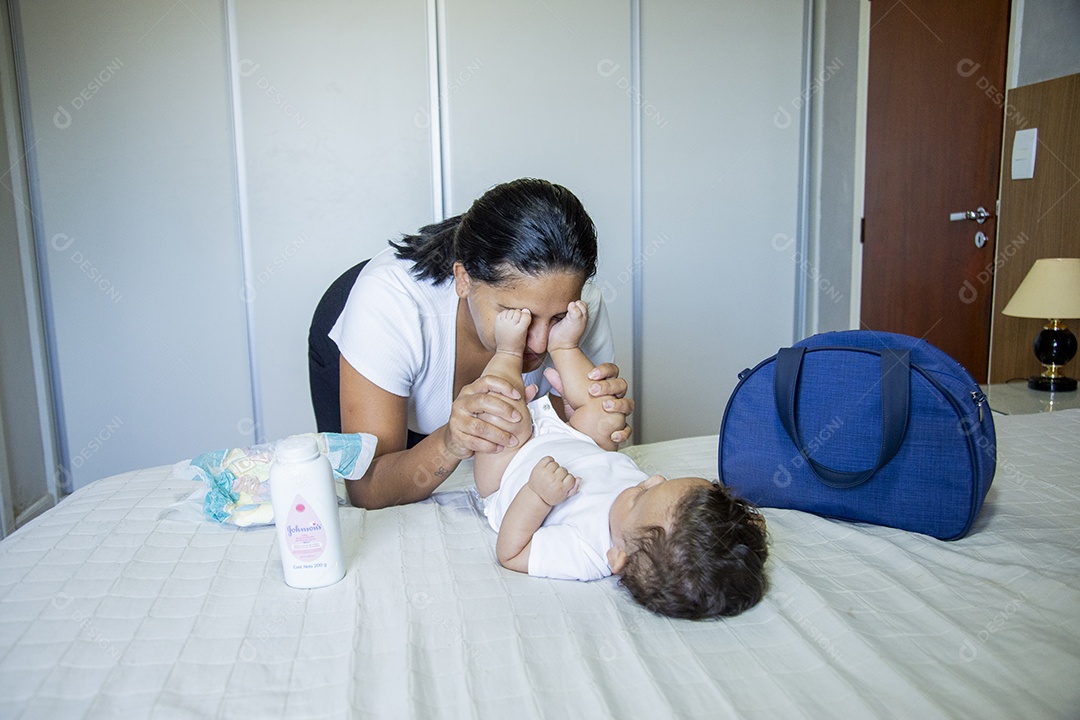 Mãe jovem cuidadando de seu filho sobre quarto