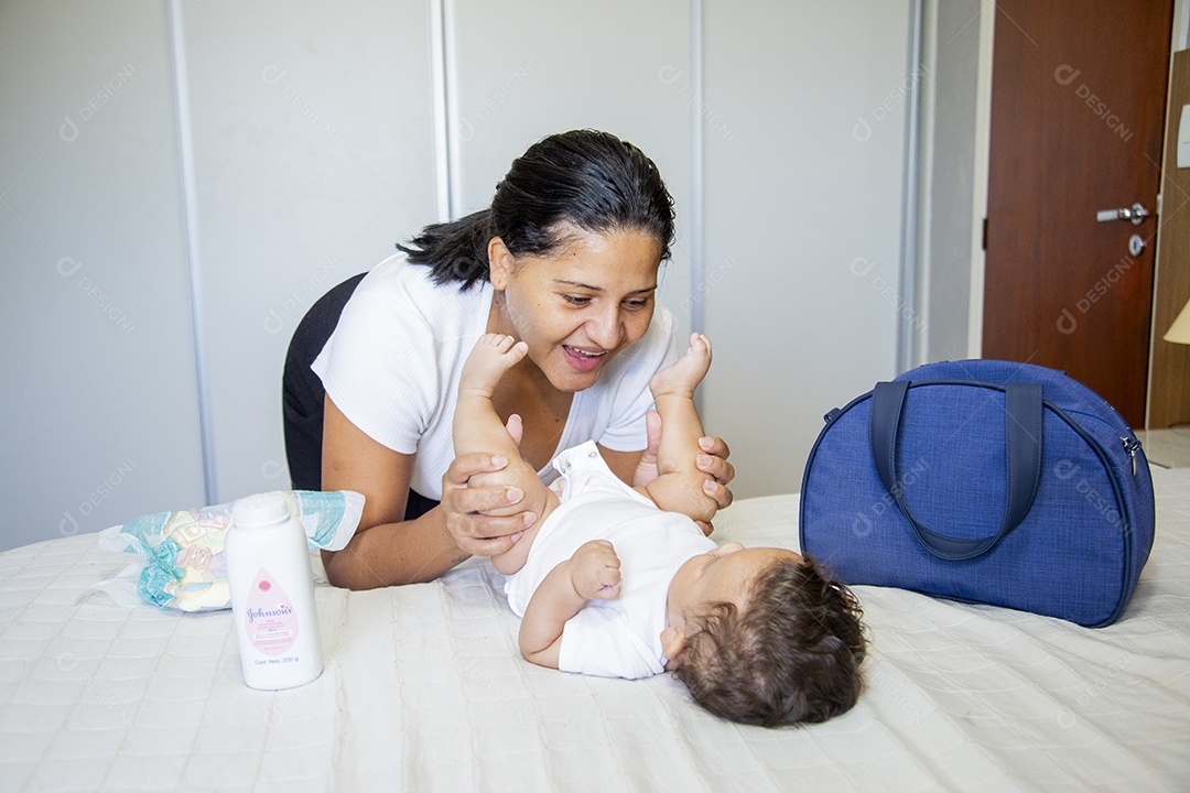 Mãe jovem cuidadando de seu filho sobre quarto