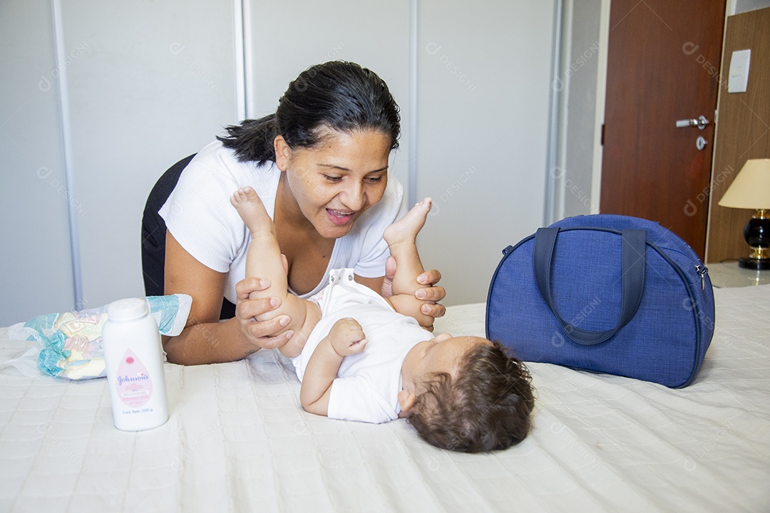 Mãe jovem cuidadando de seu filho sobre quarto