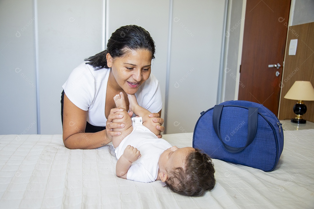 Mãe jovem cuidadando de seu filho sobre quarto
