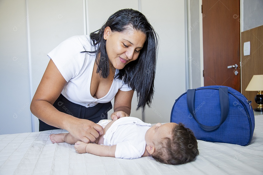 Mãe jovem cuidadando de seu filho sobre quarto