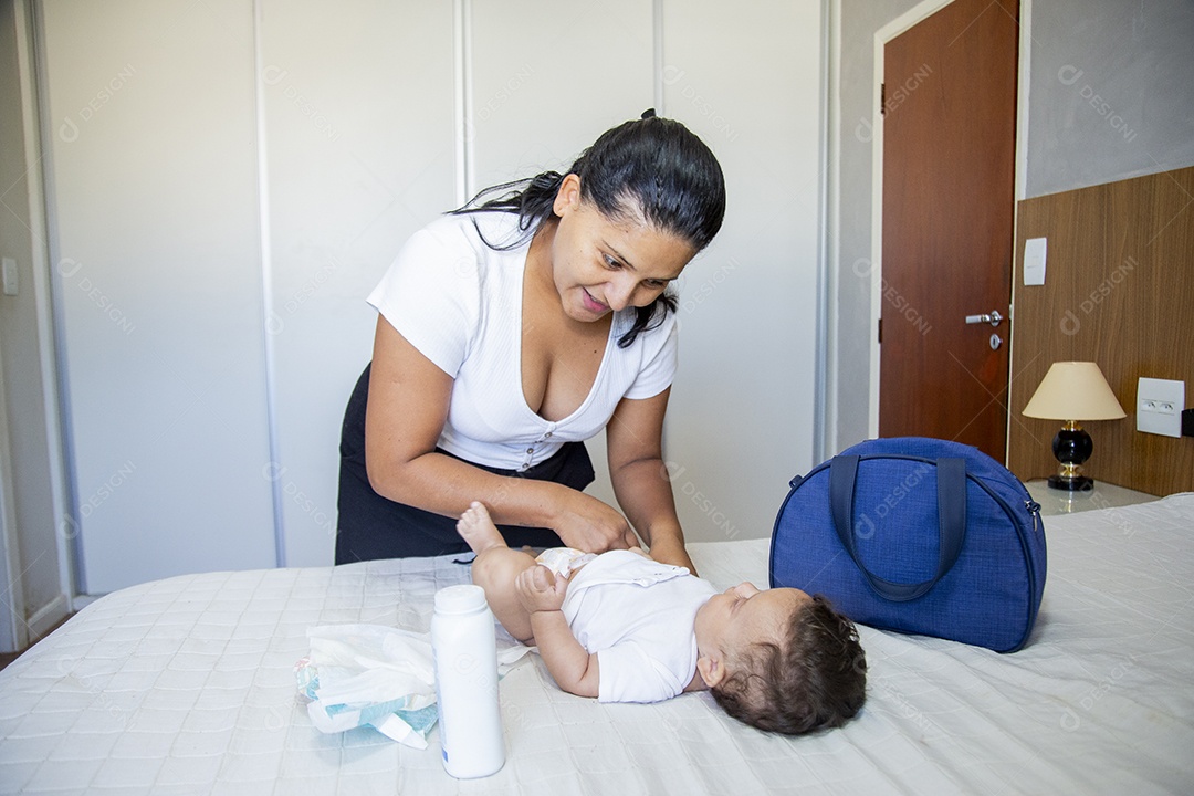 Mãe jovem cuidadando de seu filho sobre quarto
