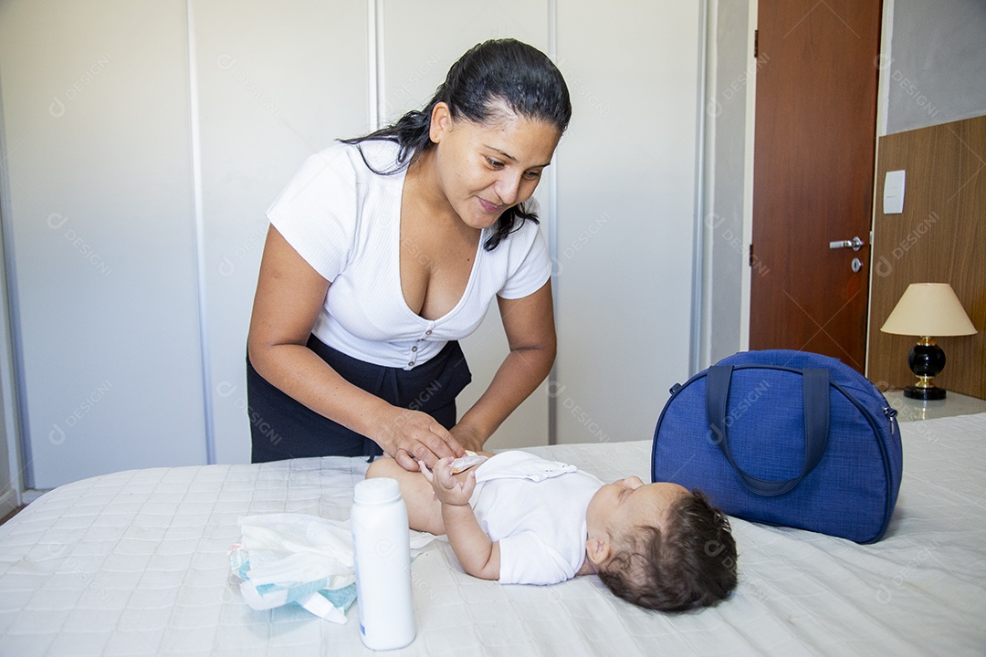Mãe jovem cuidadando de seu filho sobre quarto
