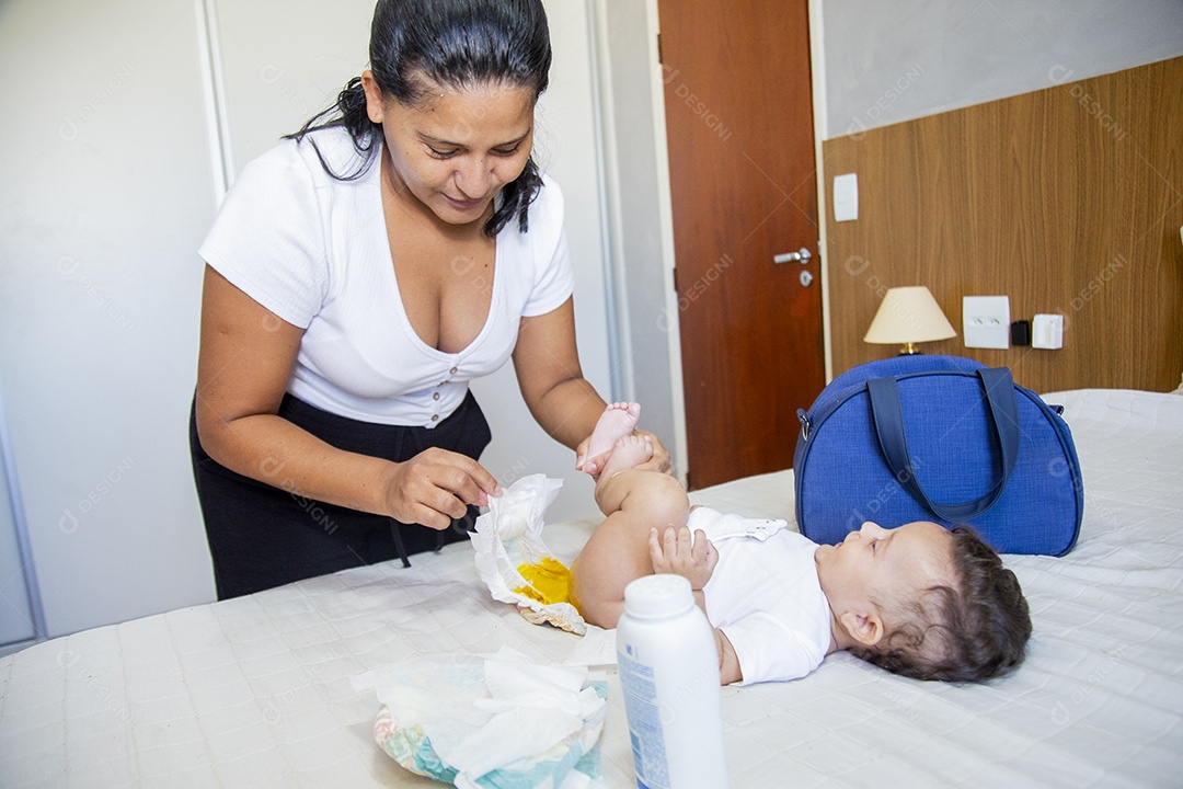 Mãe jovem cuidadando de seu filho sobre quarto