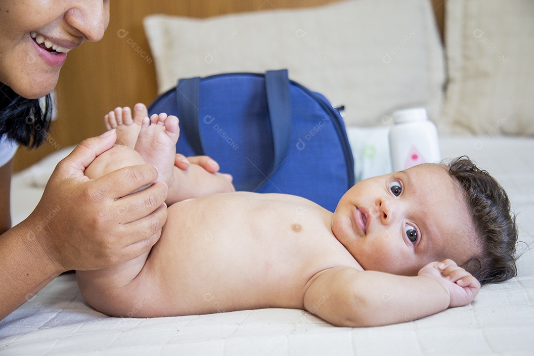 Mãe jovem cuidadando de seu filho sobre quarto