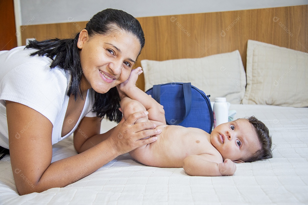 Mãe jovem cuidadando de seu filho sobre quarto