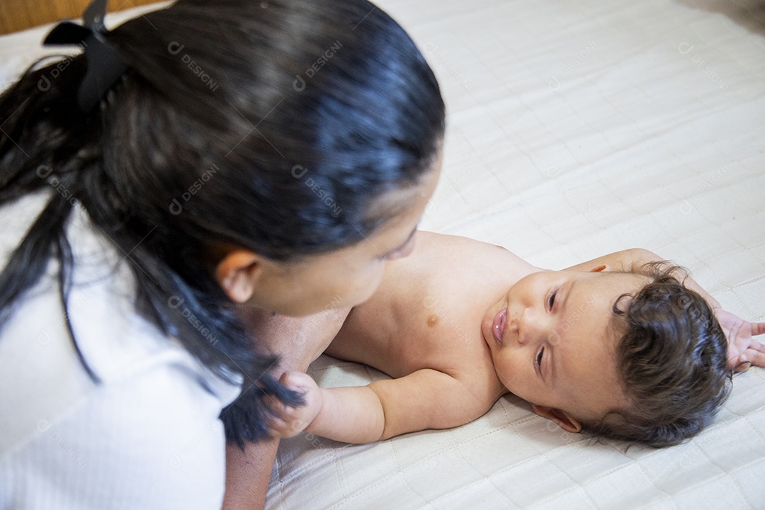 Mãe jovem cuidadando de seu filho sobre quarto