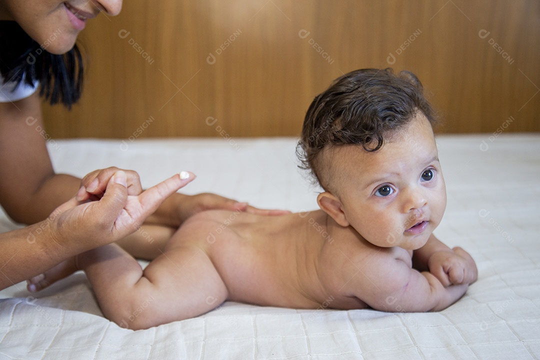 Mãe jovem cuidadando de seu filho sobre quarto