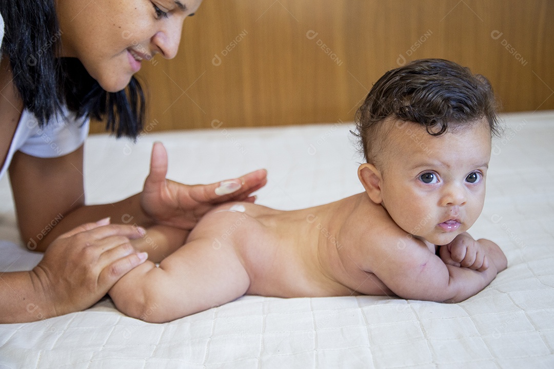 Mãe jovem cuidadando de seu filho sobre quarto