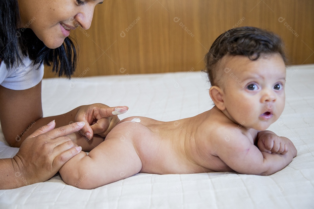 Mãe jovem cuidadando de seu filho sobre quarto