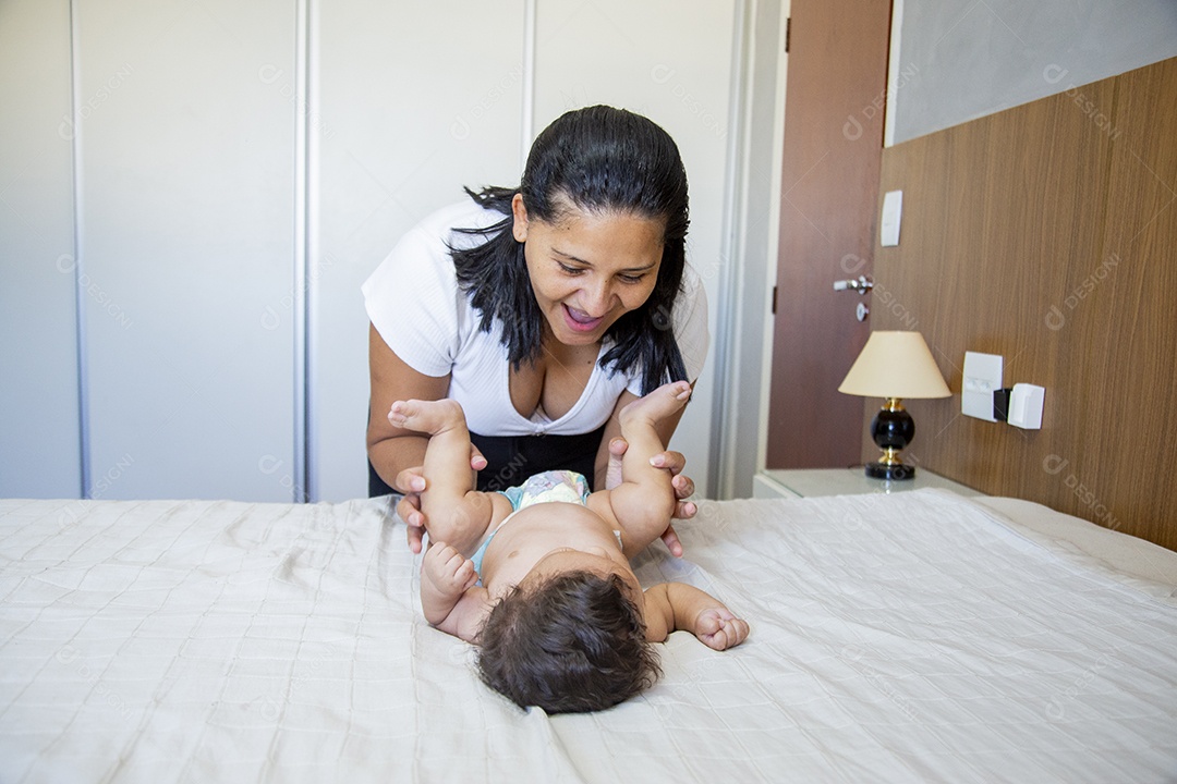 Mãe jovem cuidadando de seu filho sobre quarto