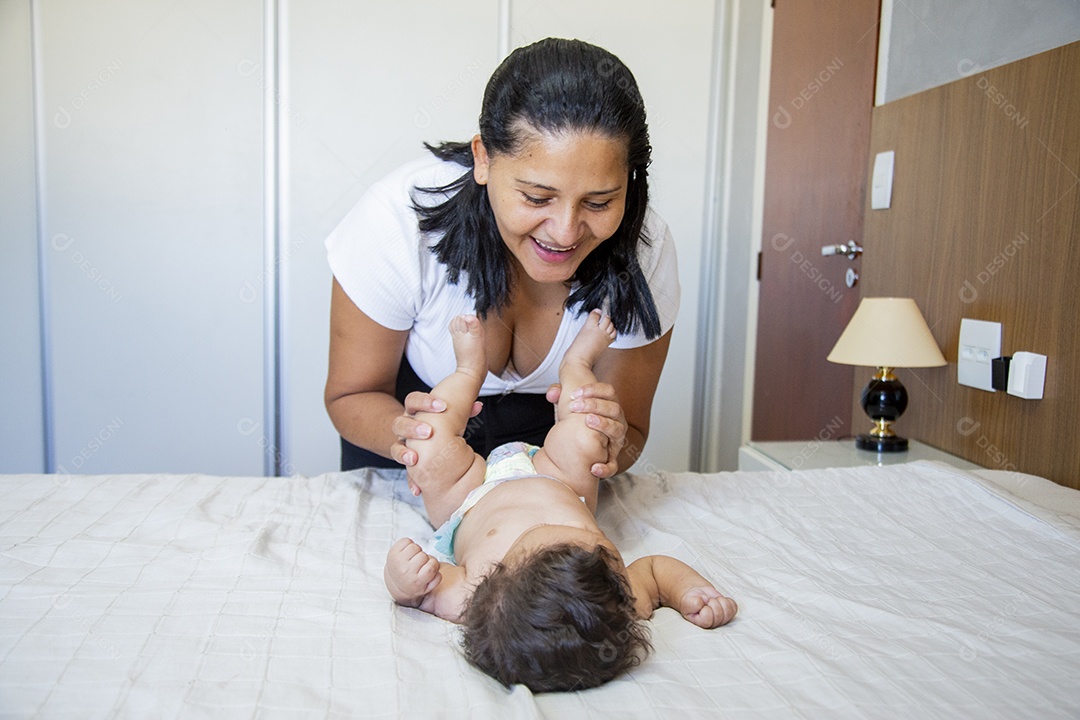Mãe jovem cuidadando de seu filho sobre quarto