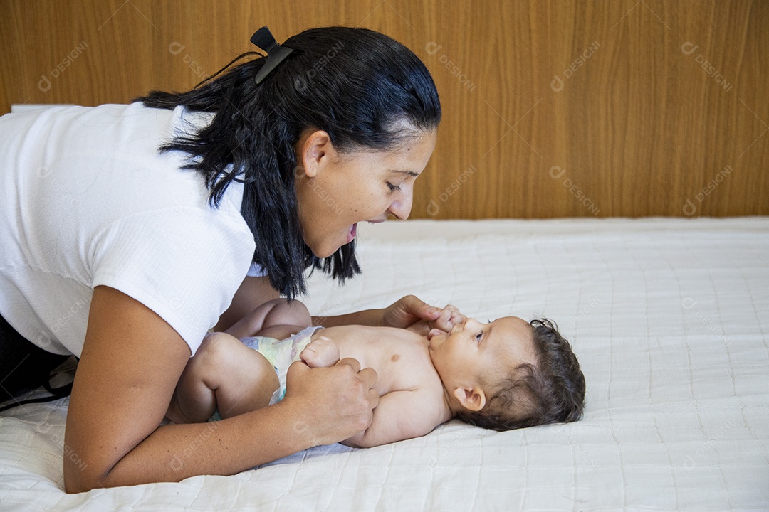 Mãe jovem cuidadando de seu filho sobre quarto