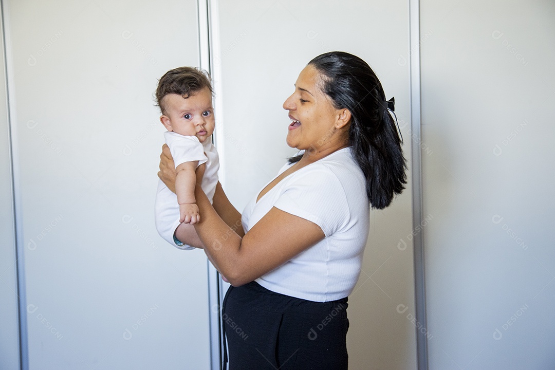 Mãe jovem segurando lindo bebê sobre quarto