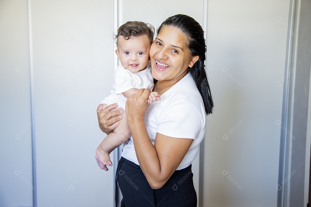 Mãe jovem cuidadando de seu filho sobre quarto