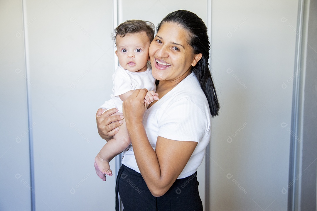 Mãe jovem cuidadando de seu filho sobre quarto