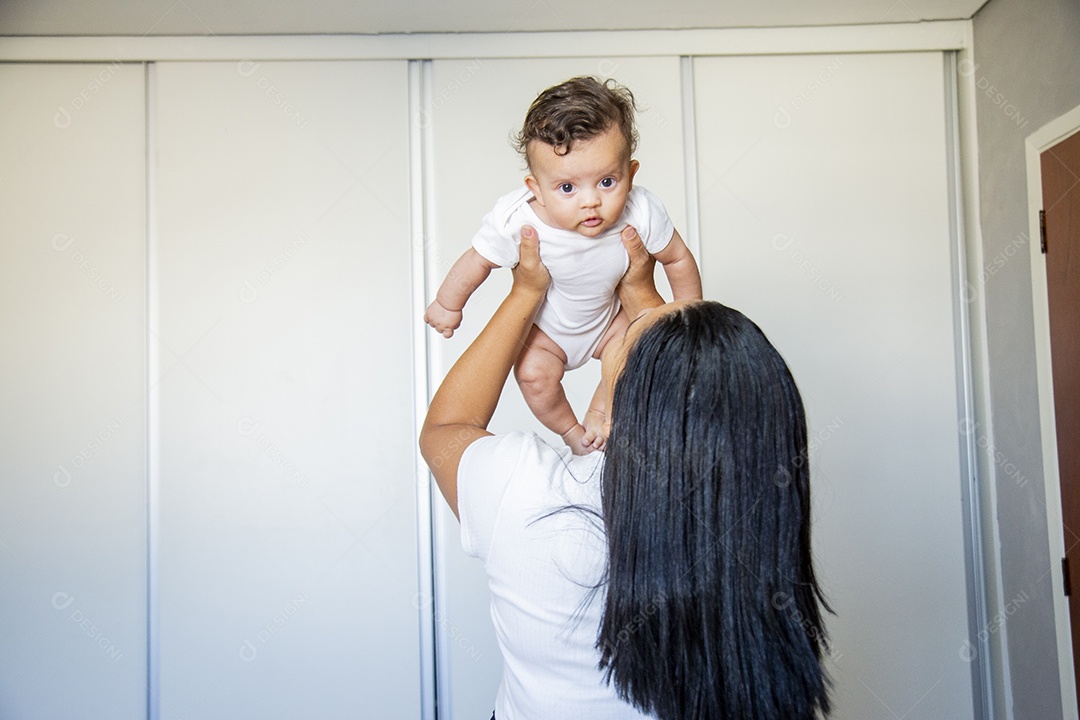 Mãe jovem cuidadando de seu filho sobre quarto