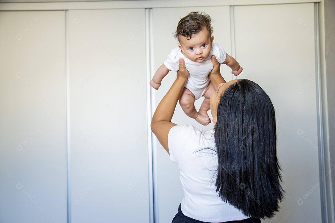Mãe jovem cuidadando de seu filho sobre quarto