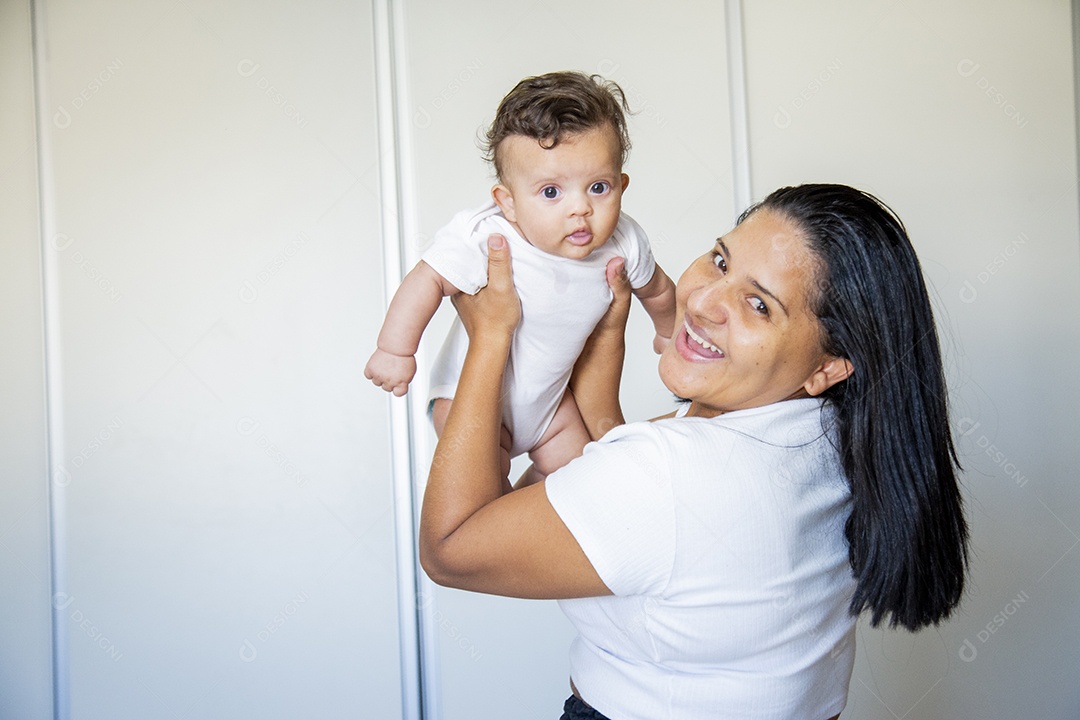 Mãe jovem cuidadando de seu filho sobre quarto
